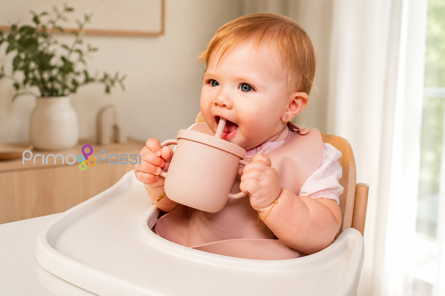 Baby using a silicone straw cup in a modern nursery.