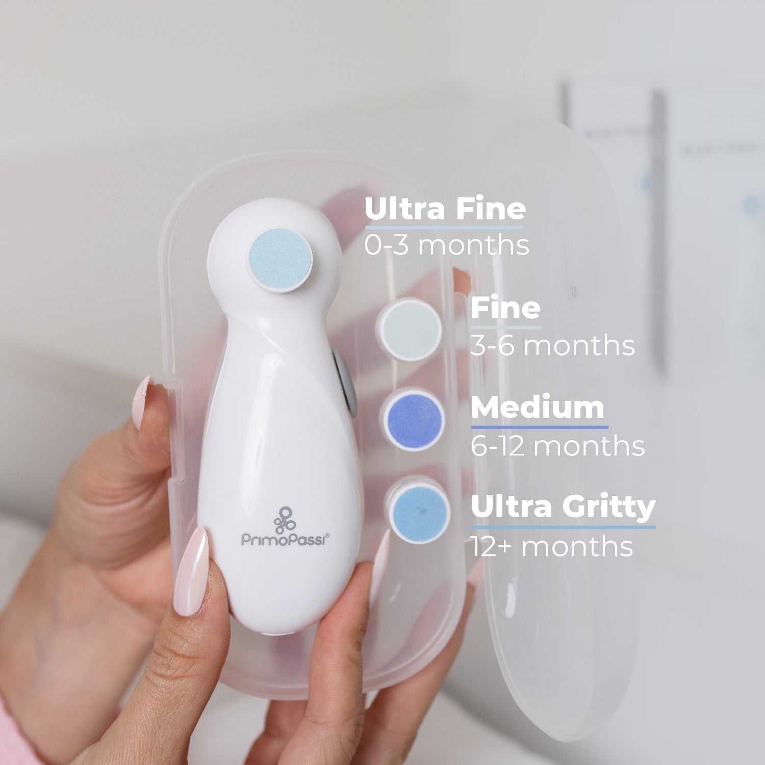 Hands holding a white electric nail filer with the description of each pad is better for each age.