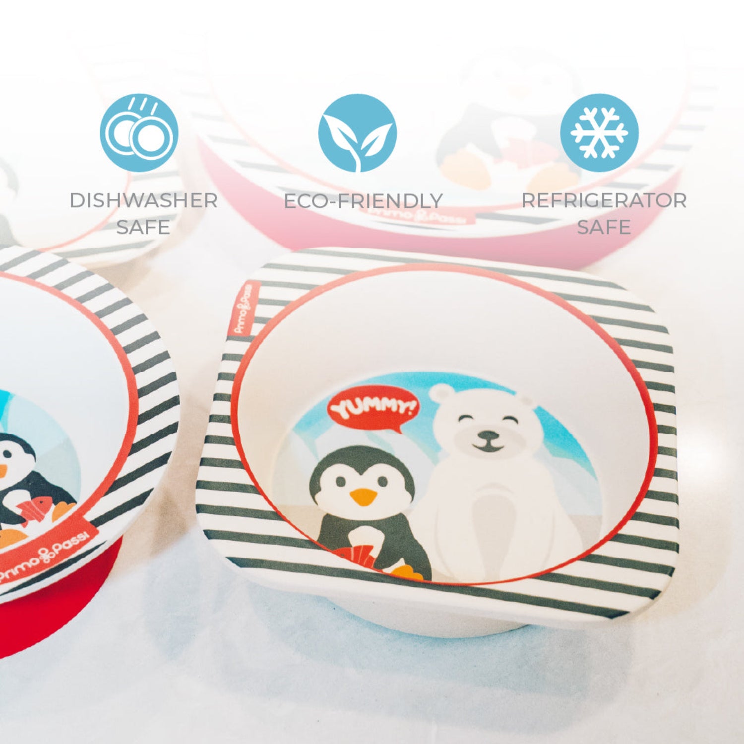 Multiple bamboo fiber children's bowls featuring a playful arctic-themed design with a smiling polar bear and a penguin. The image highlights that the bowls are dishwasher safe, eco-friendly, and refrigerator safe, making them ideal for everyday mealtime use.