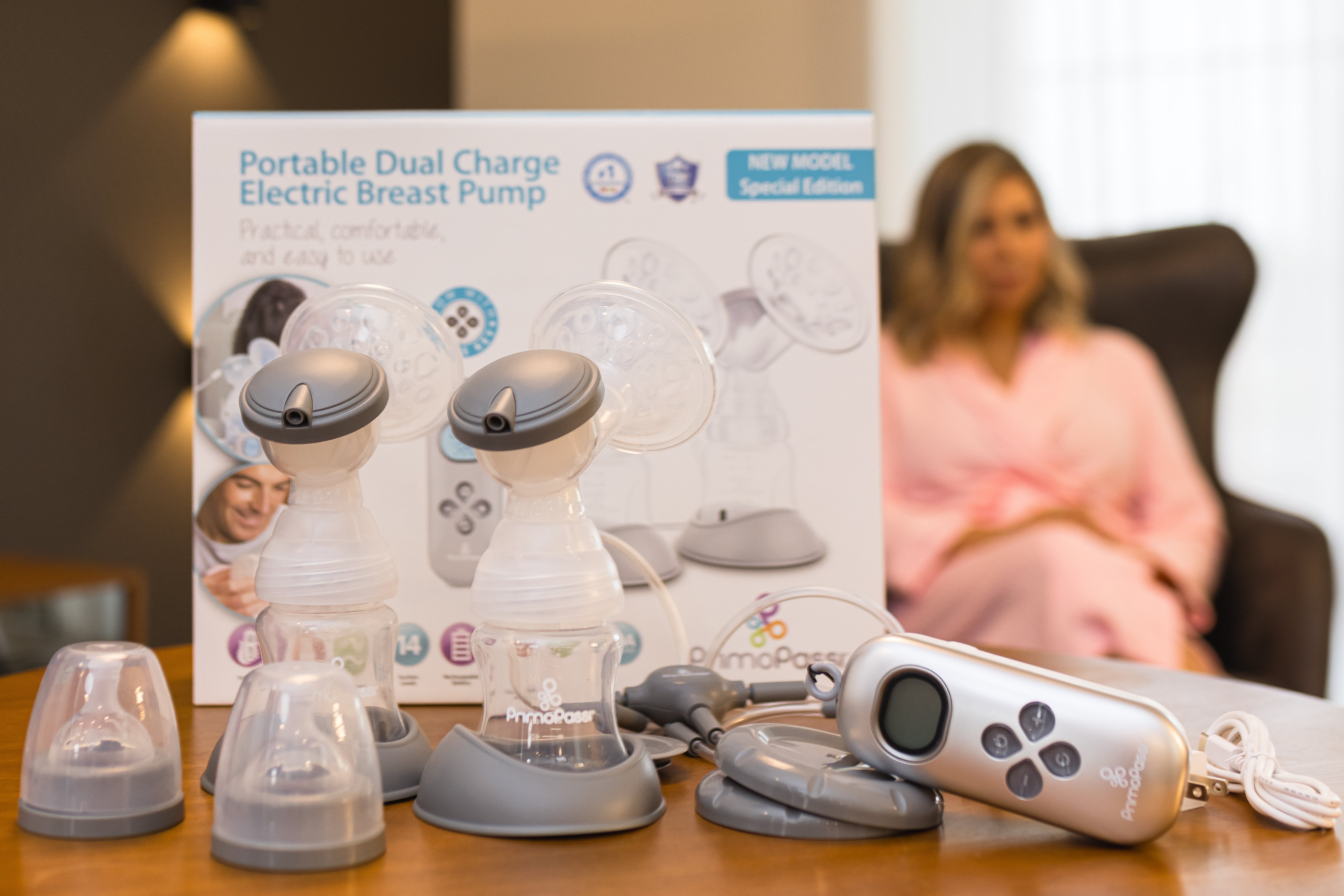 Portable dual charge electric breast pump with packaging on a table