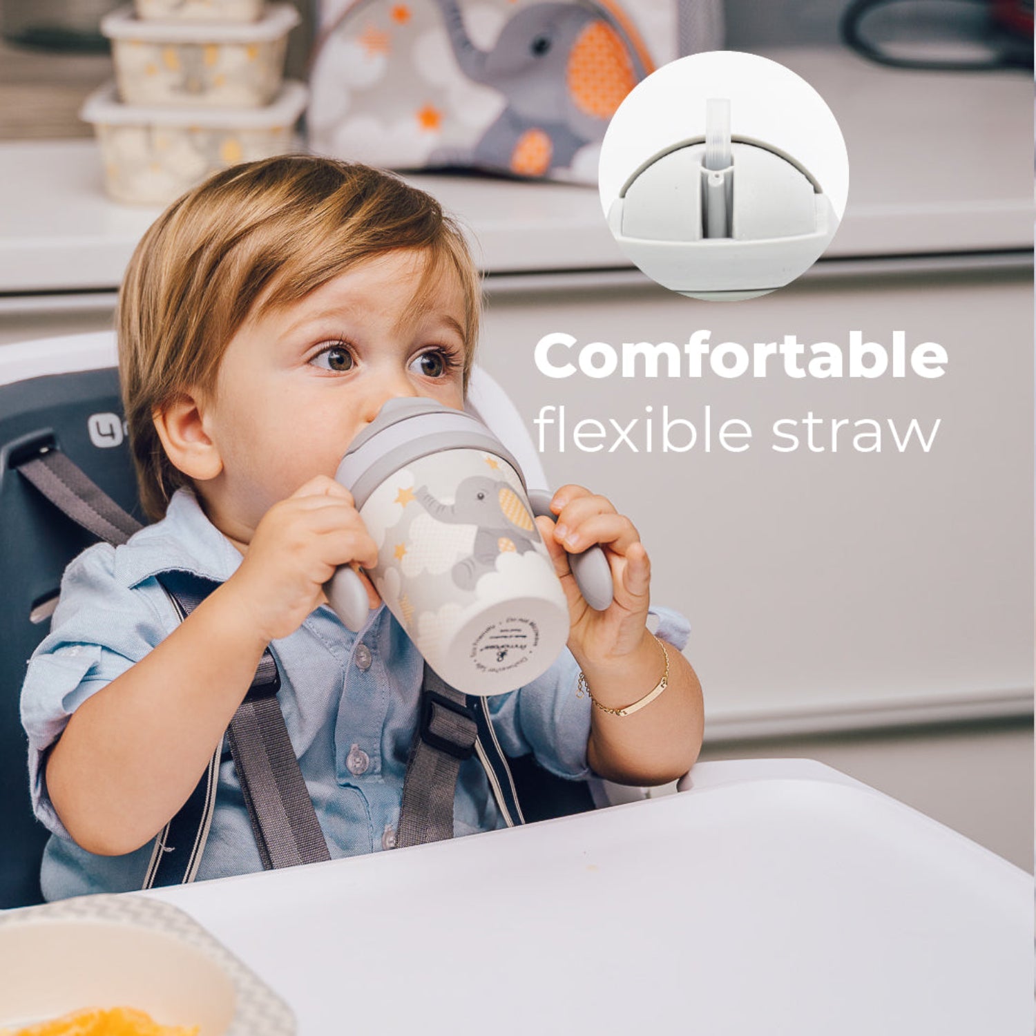 Young boy holding Gray toddler training cup with two easy-grip handles, a soft straw, and a cute elephant illustration surrounded by clouds and stars on a light background. With the text: Comfortable flexible straw