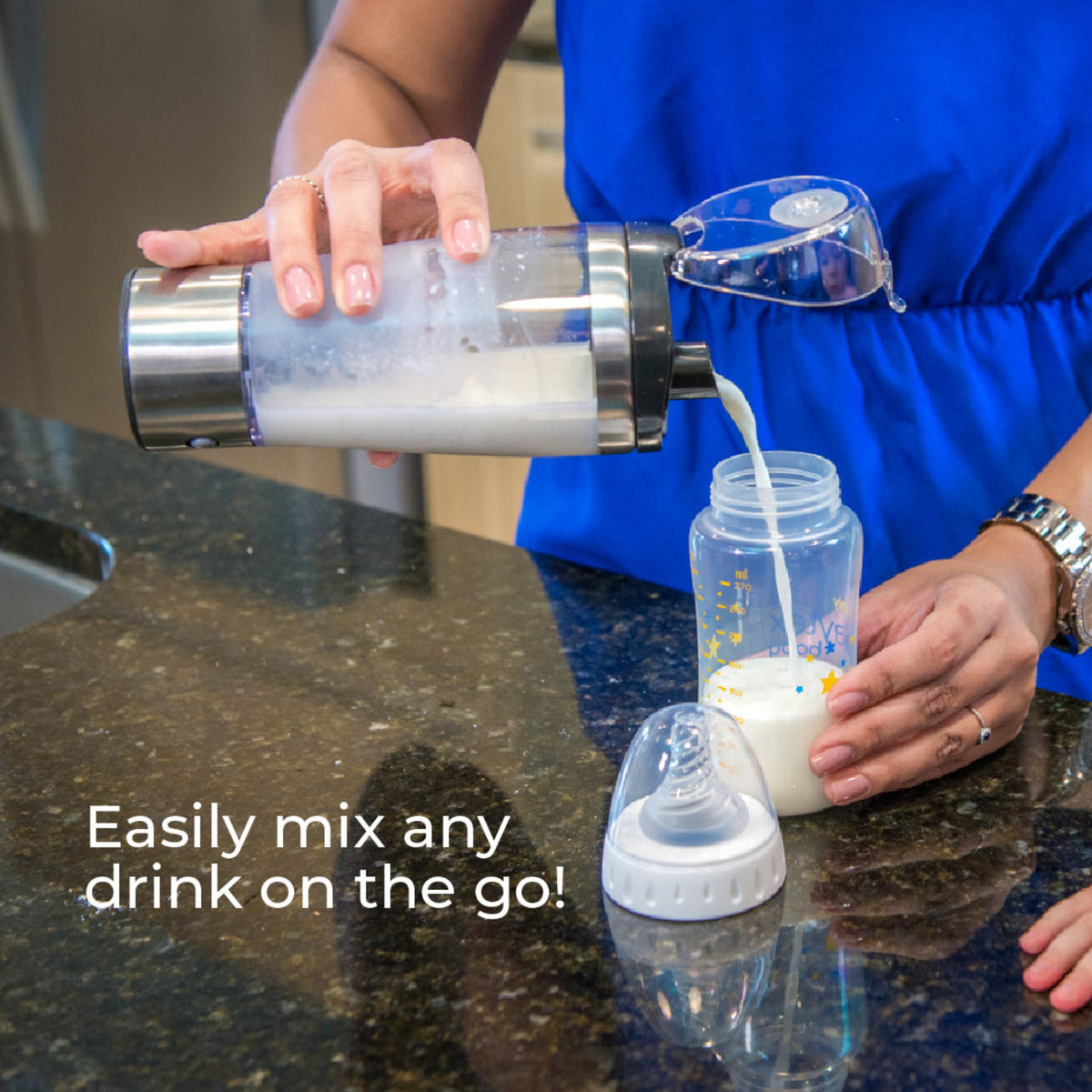 Parent pouring freshly mixed baby formula from the Primo Passi portable electric formula mixer into a baby bottle. The rechargeable mixer blends formula quickly and evenly, creating a smooth, lump-free consistency with reduced air bubbles for convenient feeding at home or on the go.