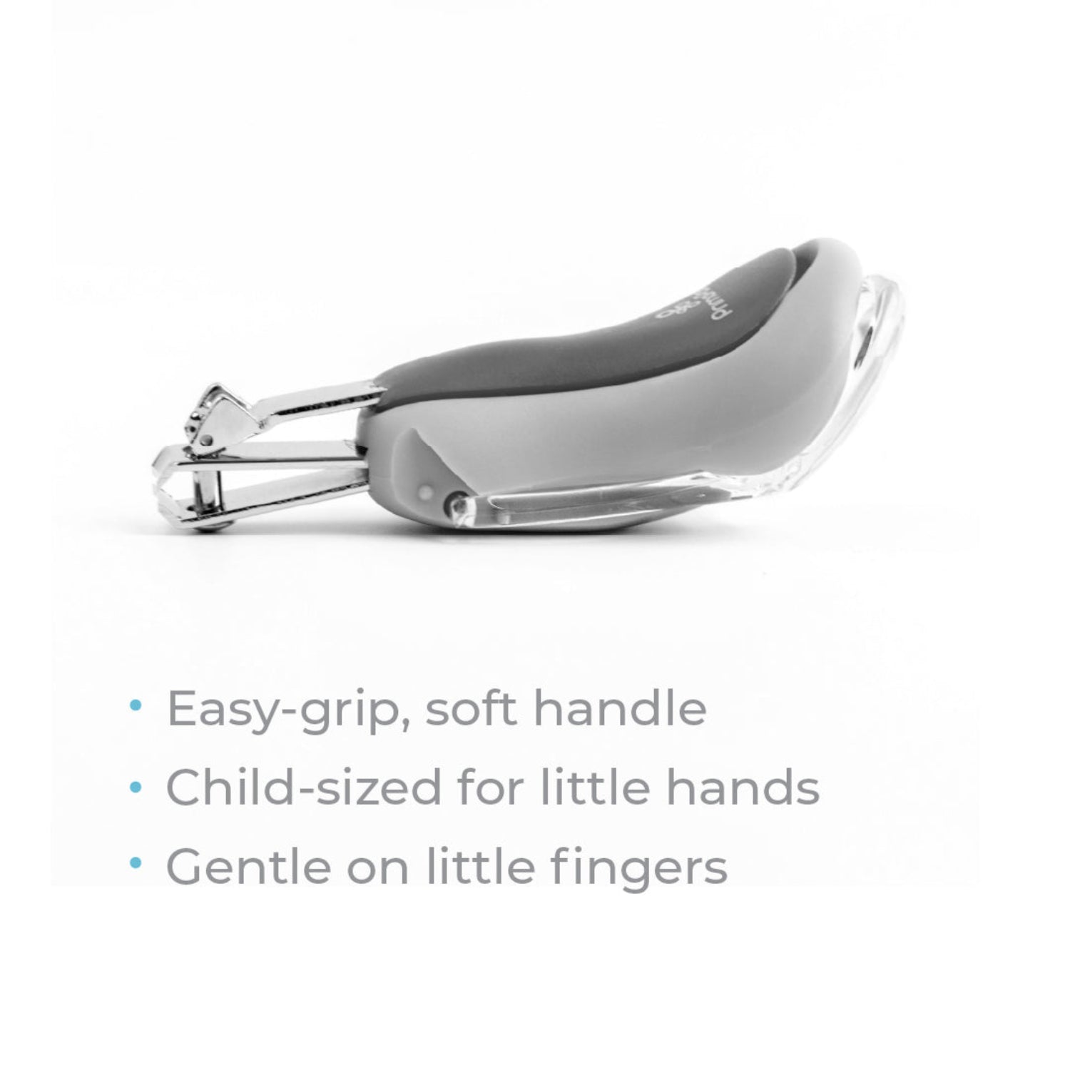 Primo Passi gray baby nail clipper with an ergonomic soft-grip handle and built-in magnifying lens displayed on a white background. The nail clipper is shown from the side, highlighting its child-sized design and protective magnifier, with feature text describing the easy-grip handle and gentle design for little fingers.