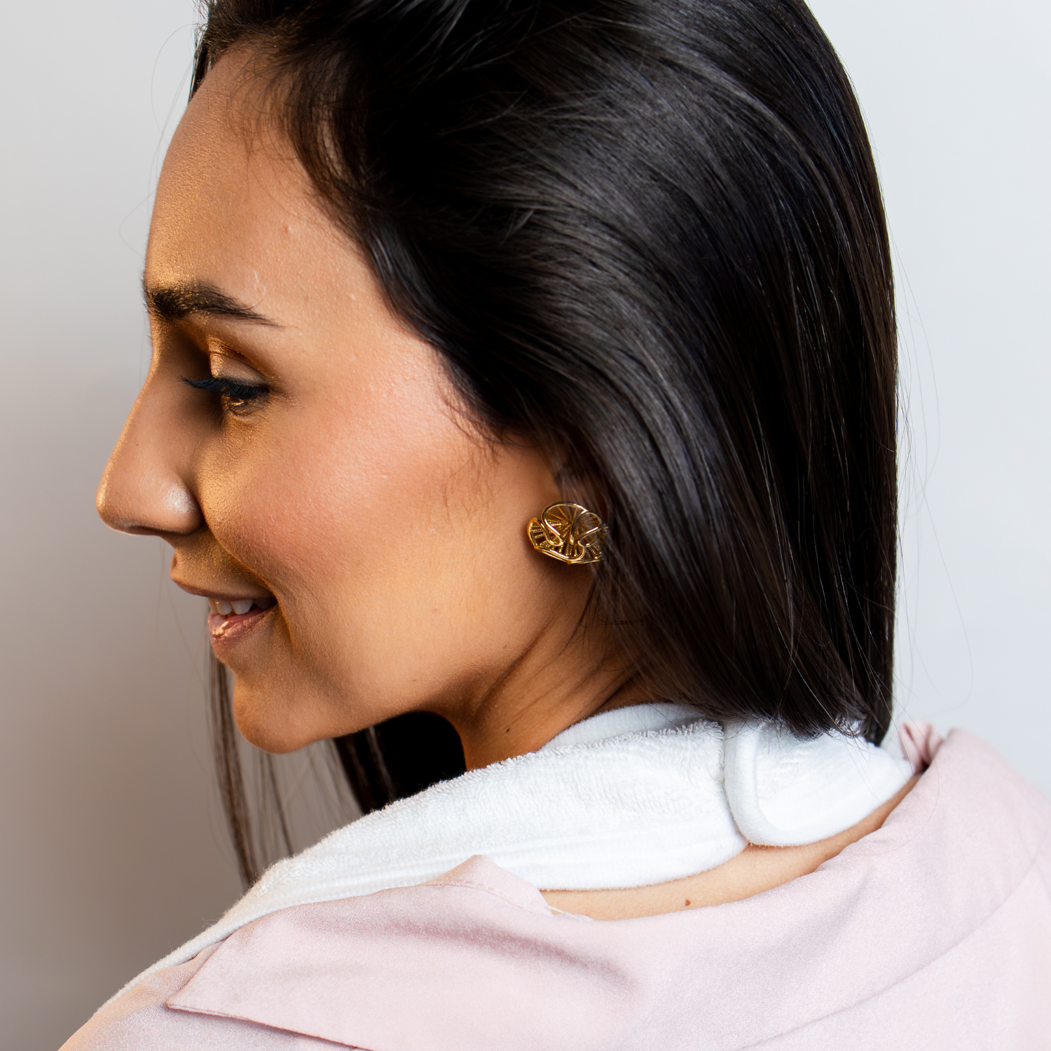 Adult wearing the Primo Passi Terry Hooded Towel around the neck in an apron-style design, keeping hands free and clothes dry during baby bath time. Made from ultra-soft, highly absorbent 100% cotton, the extra-large towel provides a comfortable, practical solution for safely lifting, drying, and cuddling babies and children up to 5 years old.