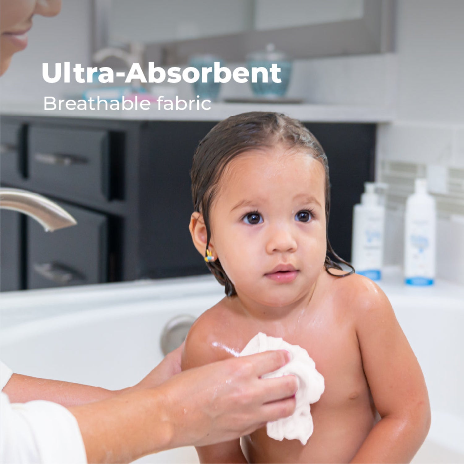 An adult gently dries a young child after bath time using a soft white muslin washcloth. The image highlights the washcloth's ultra-absorbent, breathable fabric, designed to quickly dry and comfortably care for delicate skin.