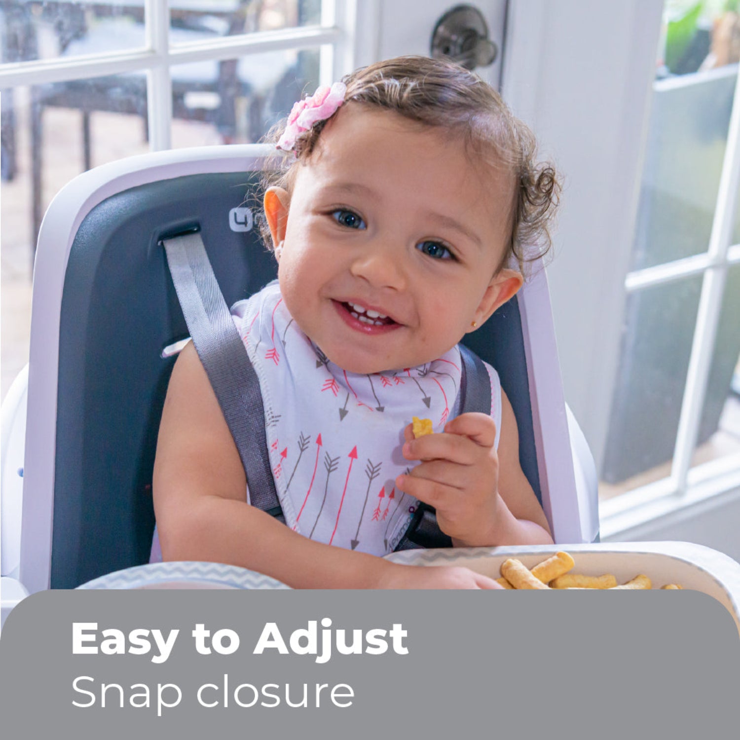 Child in a high chair with text 'Easy to Adjust Snap closure' in a casual indoor setting.