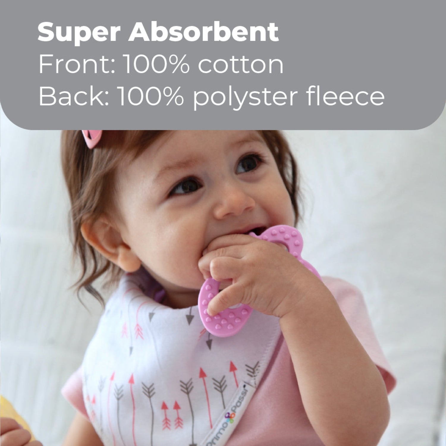 A baby wearing a white bib with a pink and gray arrow pattern, holding a pink teether. A gray text banner at the top reads 'Super Absorbent Front: 100% cotton Back: 100% polyester fleece'.