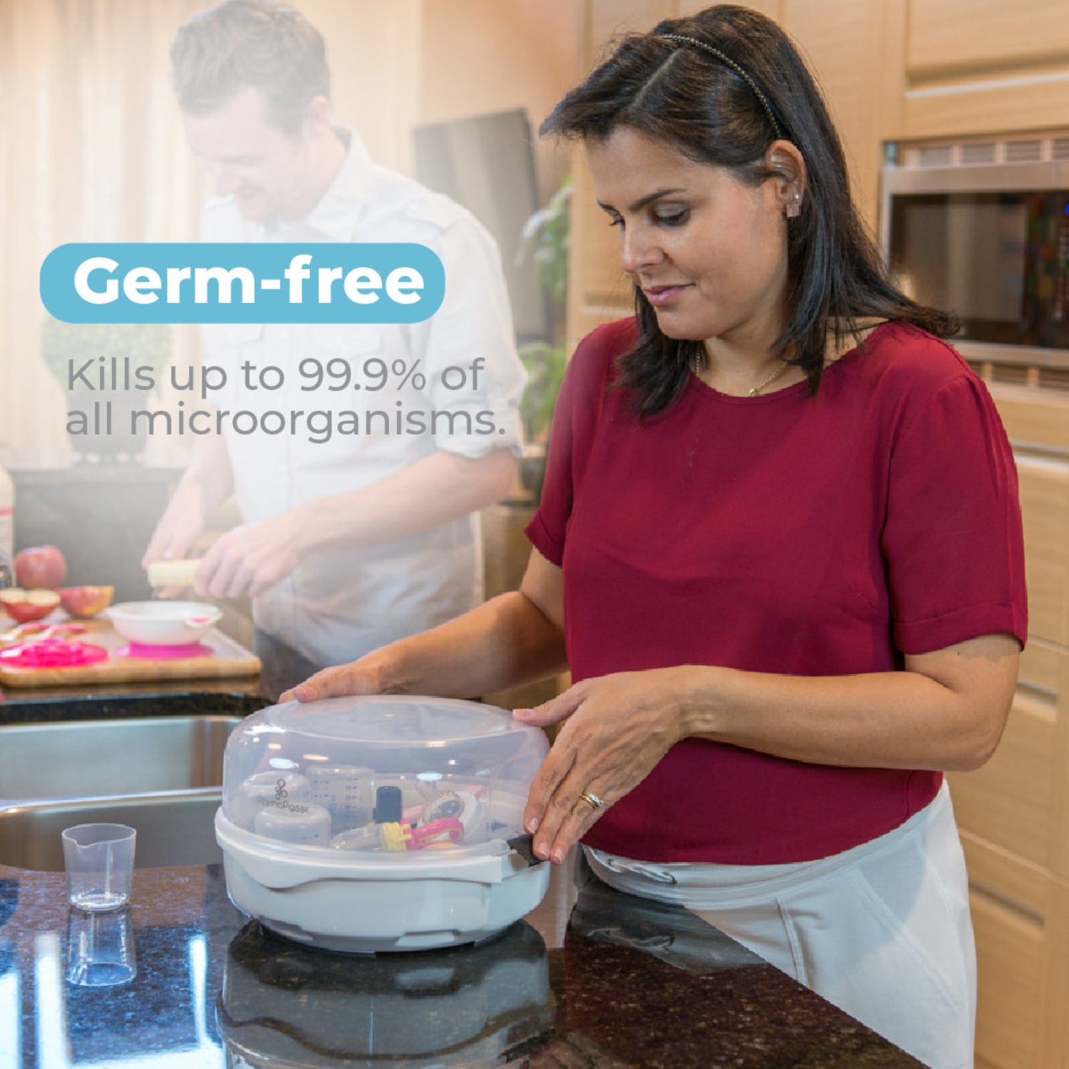 Parent securing the Primo Passi microwave steam sterilizer on a kitchen countertop after sterilizing baby bottles and accessories, with text highlighting germ-free sterilization that kills up to 99.9% of microorganisms.