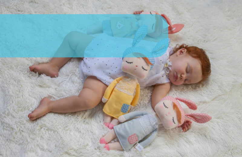 Baby Sleeping with a Newborn Fabric Doll