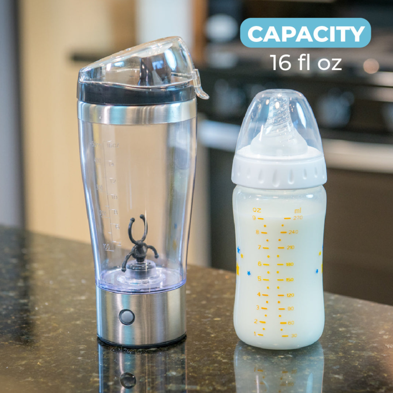 Primo Passi Portable Formula Mixer displayed next to a baby bottle on a kitchen countertop. The 16 fl oz mixer features a stainless steel base, clear blending cup with integrated mixing blade, and secure flip-top lid, making it easy to prepare smooth, lump-free formula or drinks at home or on the go.