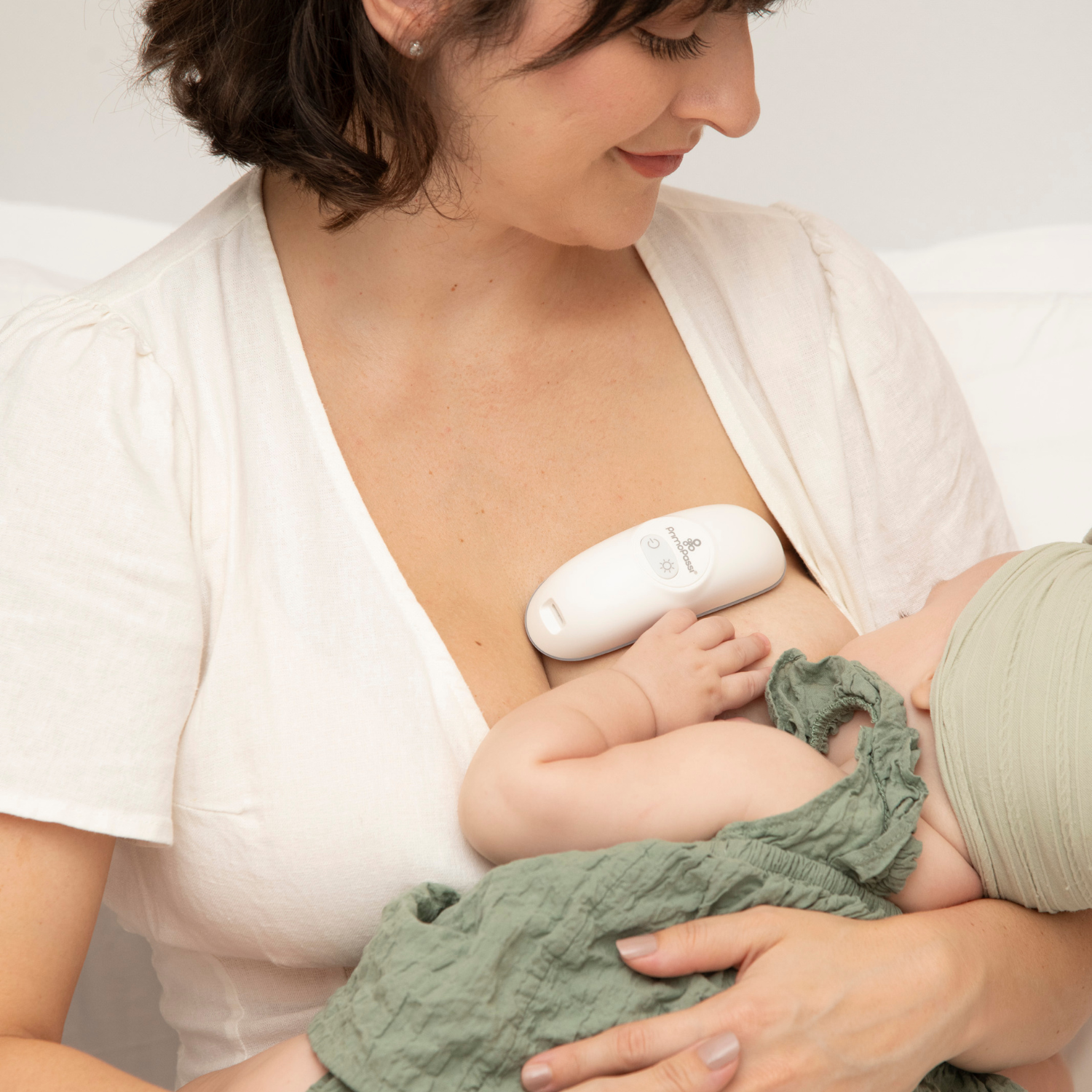 a mom breastfeeding the baby using the lactation massager device
